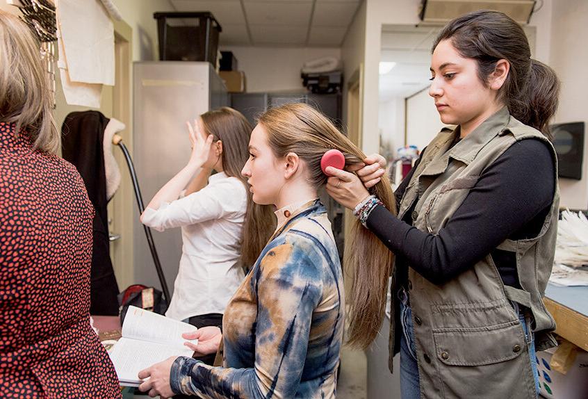 Alexandra Nava-Baltimore works backstage doing hair and makeup for performance.